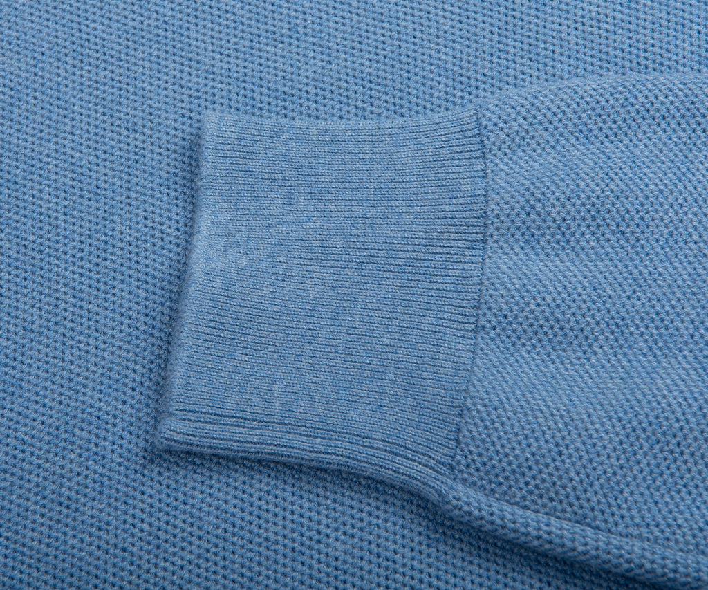 Close-up of a blue textured fabric with a pocket detail