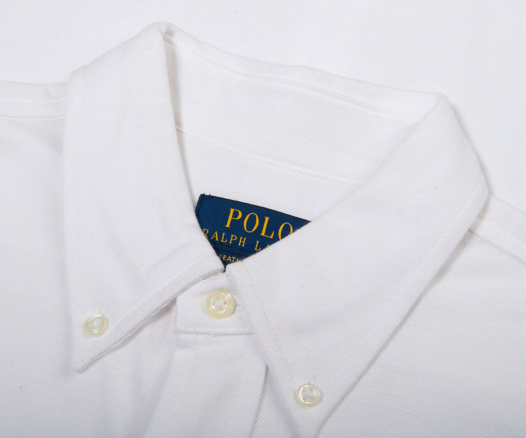 Close-up of a white shirt with a Polo Ralph Lauren label on a white background