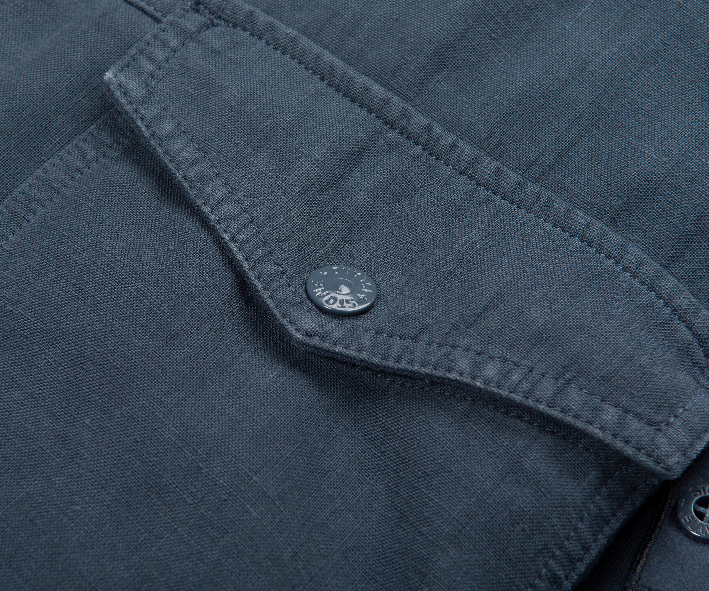 Close-up of a dark gray shirt pocket with a button, featuring the brand 'MOSS'.