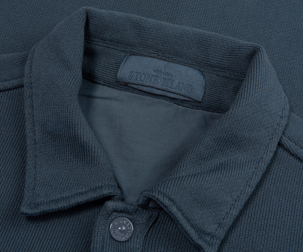 Close-up of a dark gray polo shirt with Stone Island label