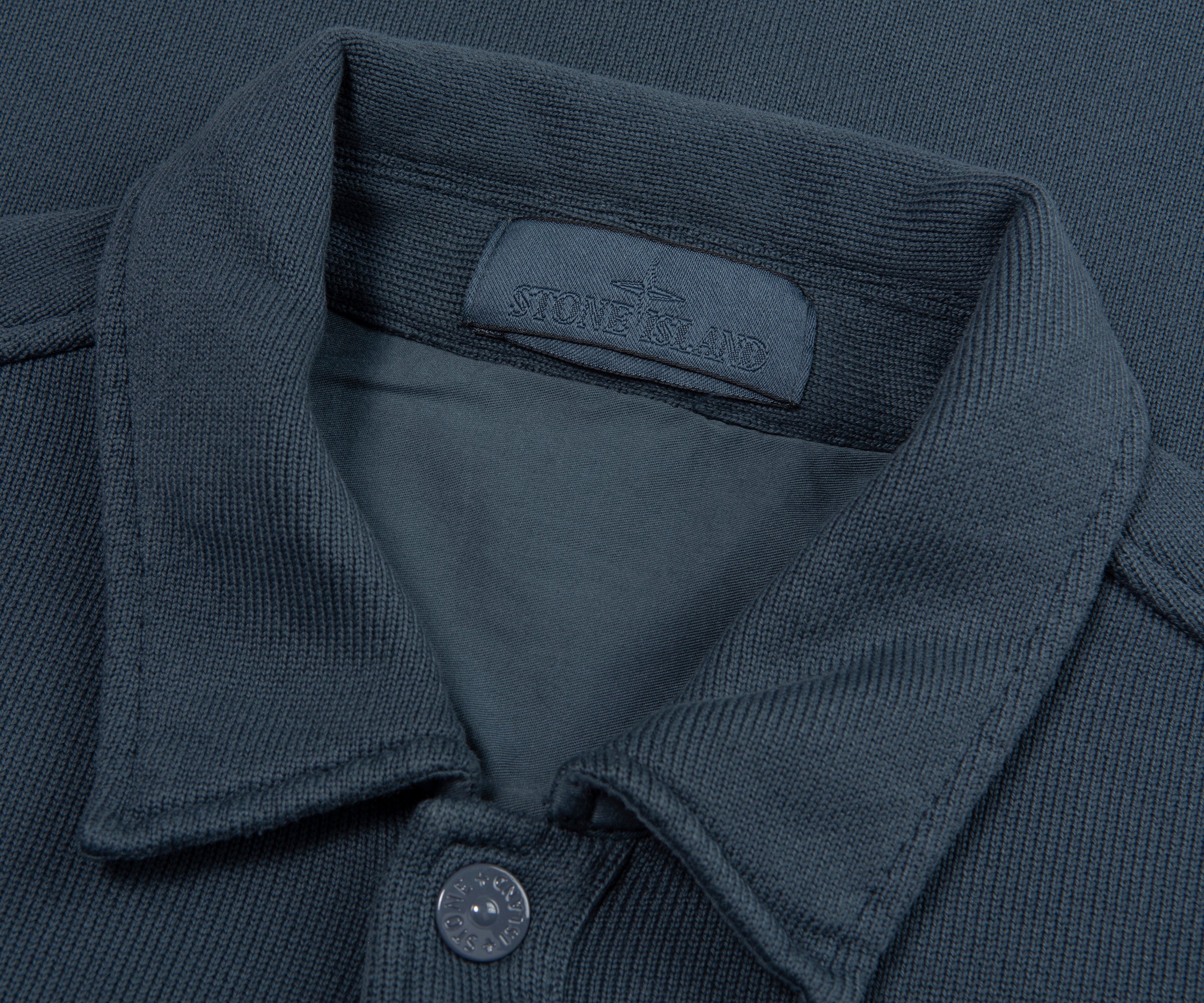 Close-up of a dark gray polo shirt with Stone Island label