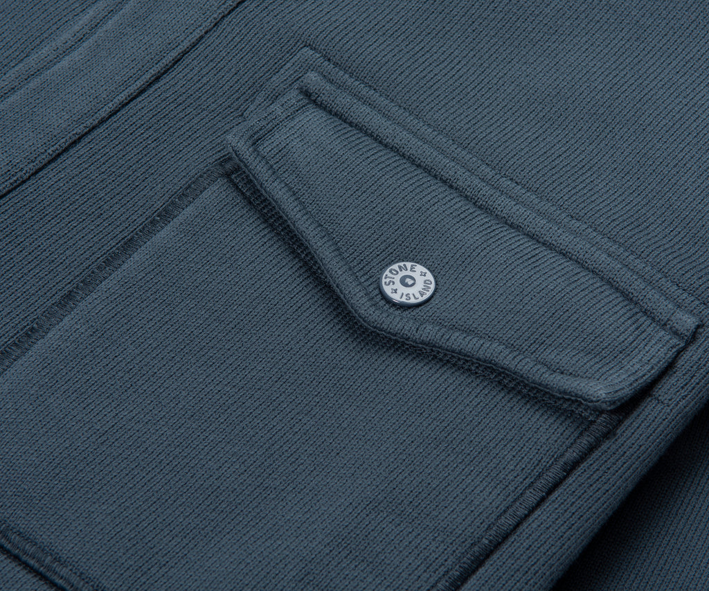 Close-up of a dark gray fabric with a button, likely from a jacket or coat.