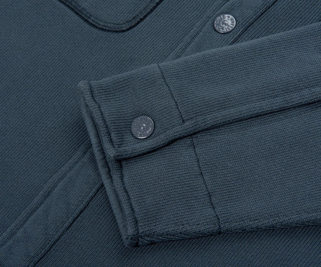 Close-up of a dark blue fabric with buttons and folded edge