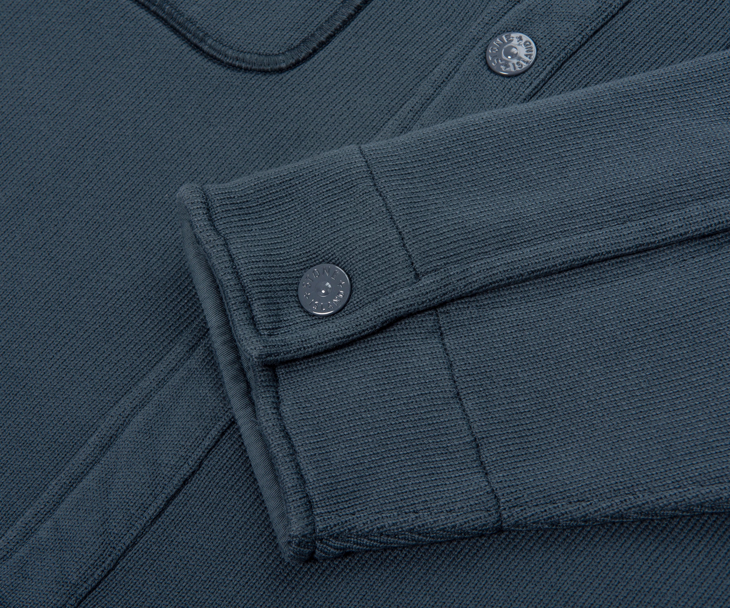 Close-up of a dark blue fabric with buttons and folded edge