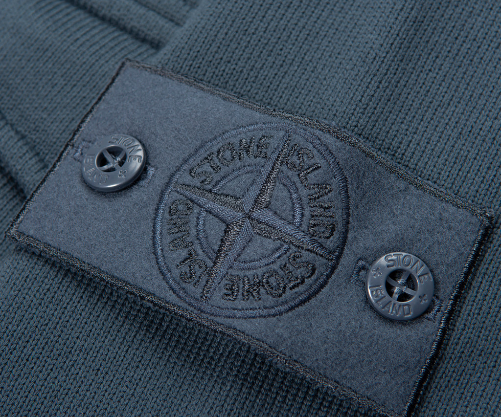 Close-up of a Stone Island label on a garment with a detailed emblem.