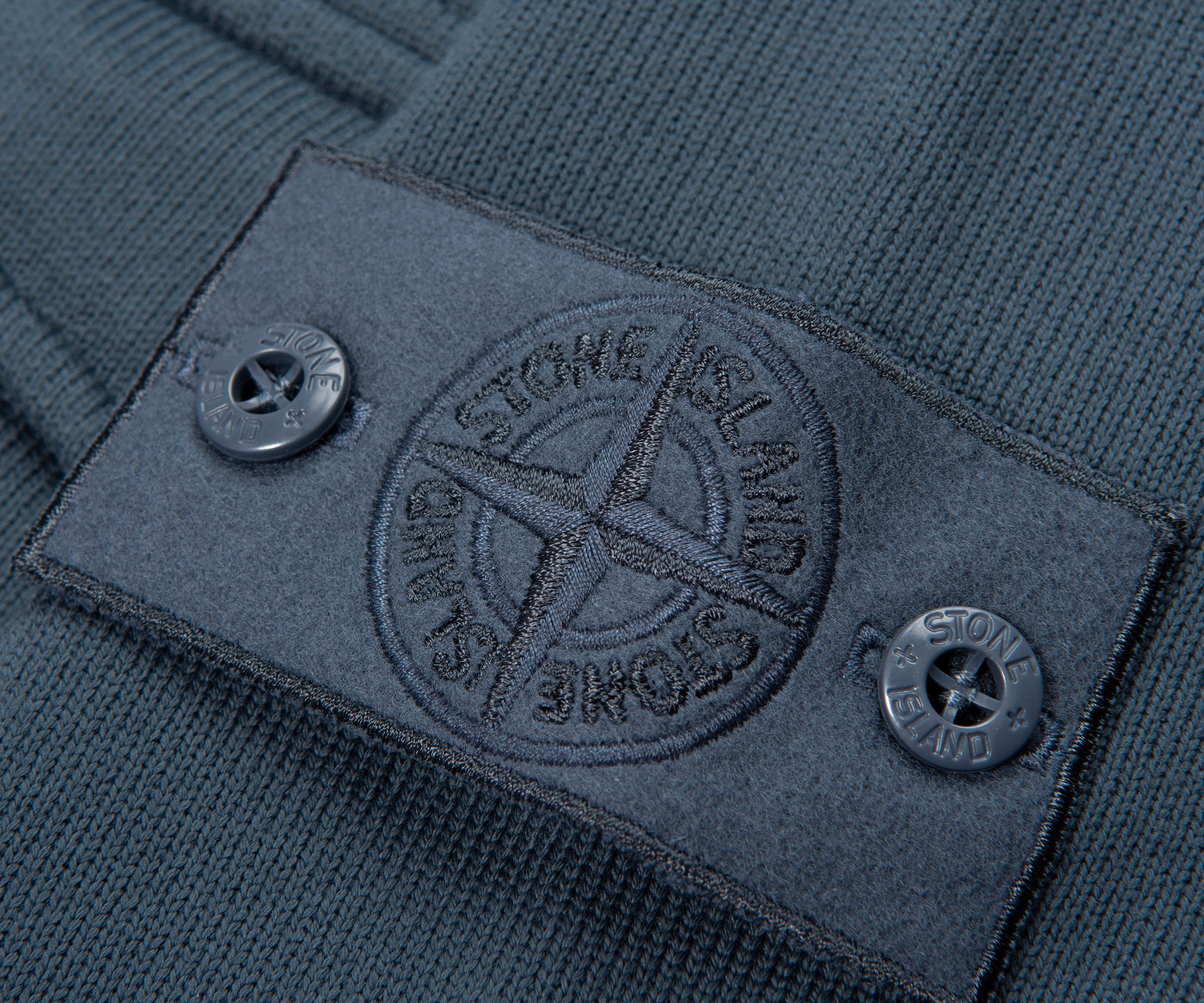 Close-up of a Stone Island label on a garment with a detailed emblem.