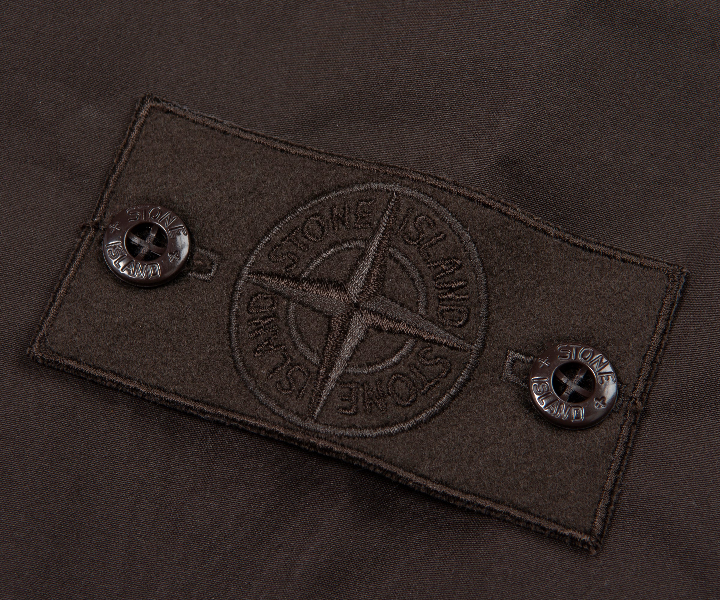 Close-up of a brand label on a dark fabric background