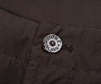 Close-up of a button on a dark fabric with 'Massone Island' branding.