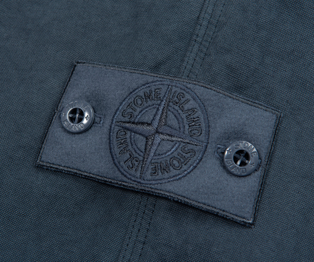 Close-up of a Stone Island label on a dark fabric background