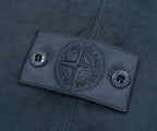 Close-up of a Stone Island label on a dark fabric background