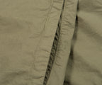 Close-up of olive green fabric with stitching detail