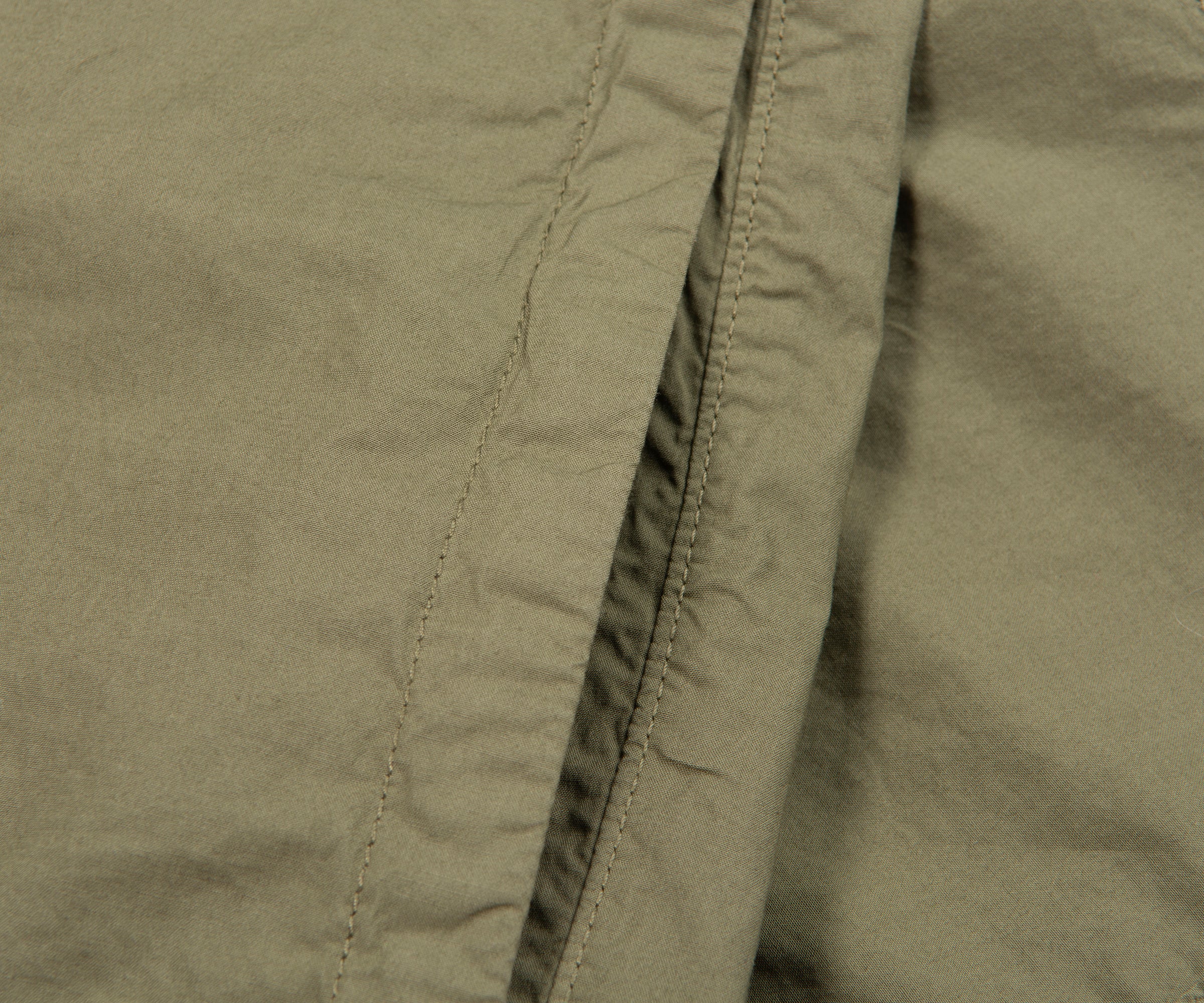 Close-up of olive green fabric with stitching detail