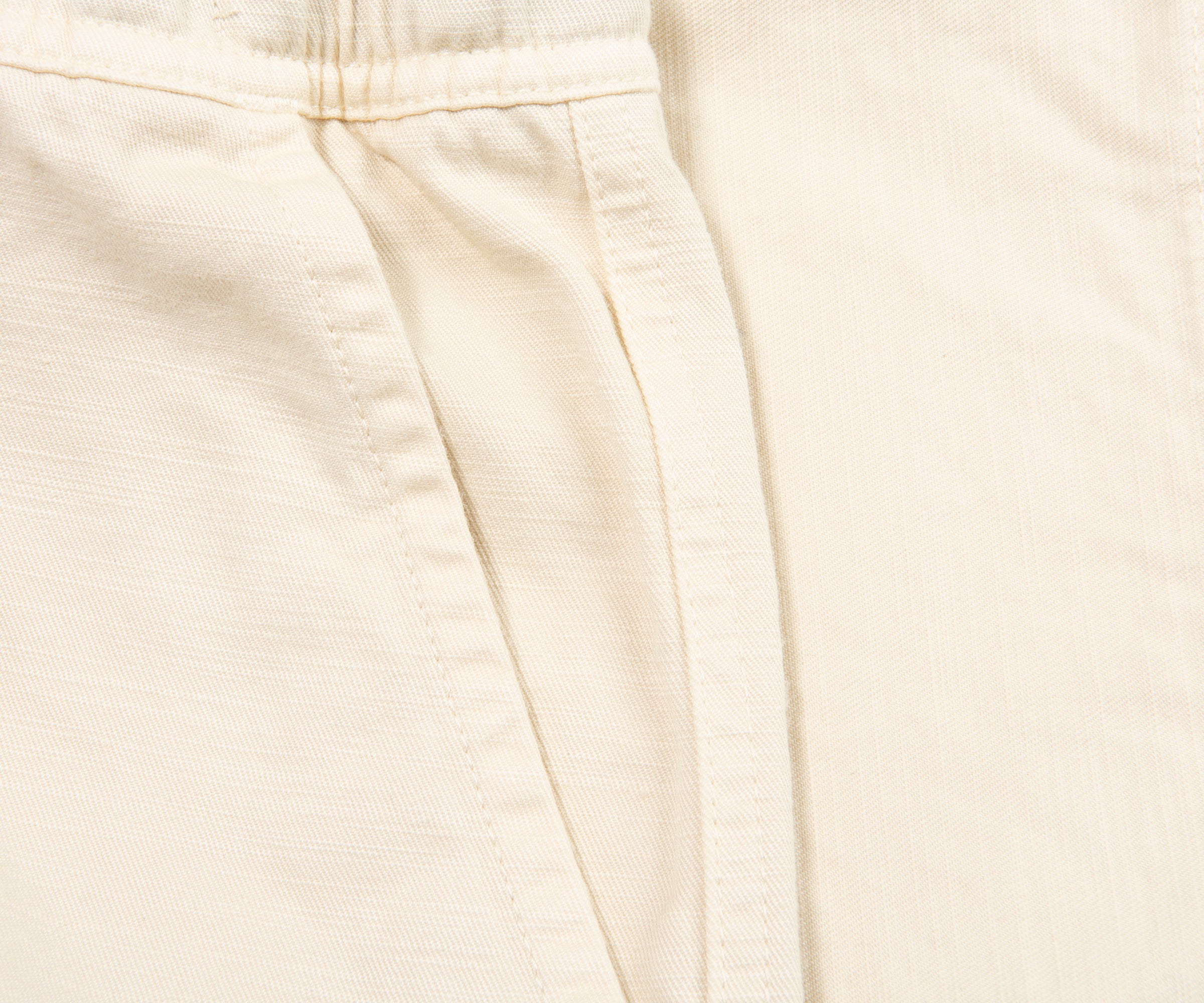 Close-up of beige pants with a focus on texture and folds.