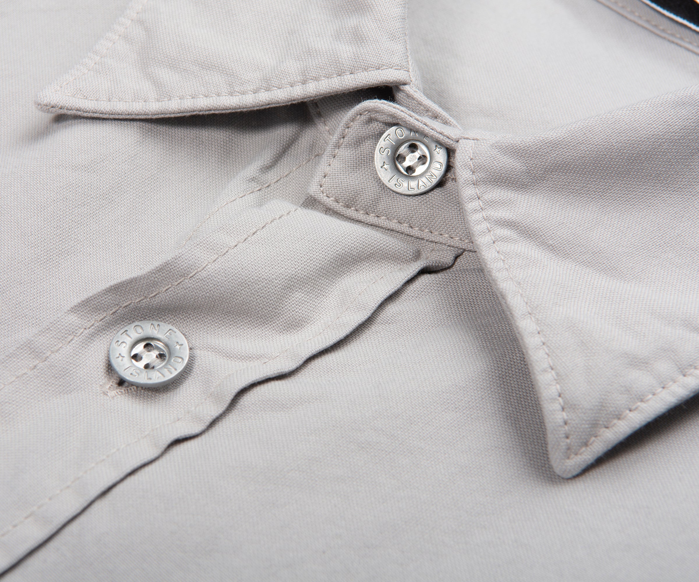 Close-up of a light gray shirt collar with buttons