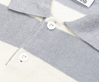 Close-up of a gray and white striped sweater with buttons, brand label visible.