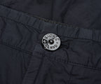 Close-up of a button on a dark fabric with 'New Zealand' branding.