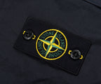 Close-up of a Stone Island logo patch on a dark fabric background