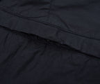 Close-up of a black quilted jacket with stitching detail