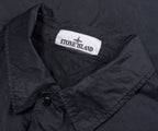 Close-up of a black jacket with Stone Island logo on the collar.