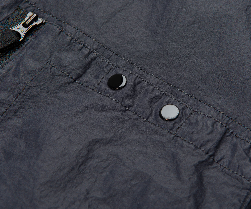 Close-up of a dark gray fabric with a zipper and buttons.