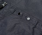Close-up of a dark gray fabric with a zipper and buttons.