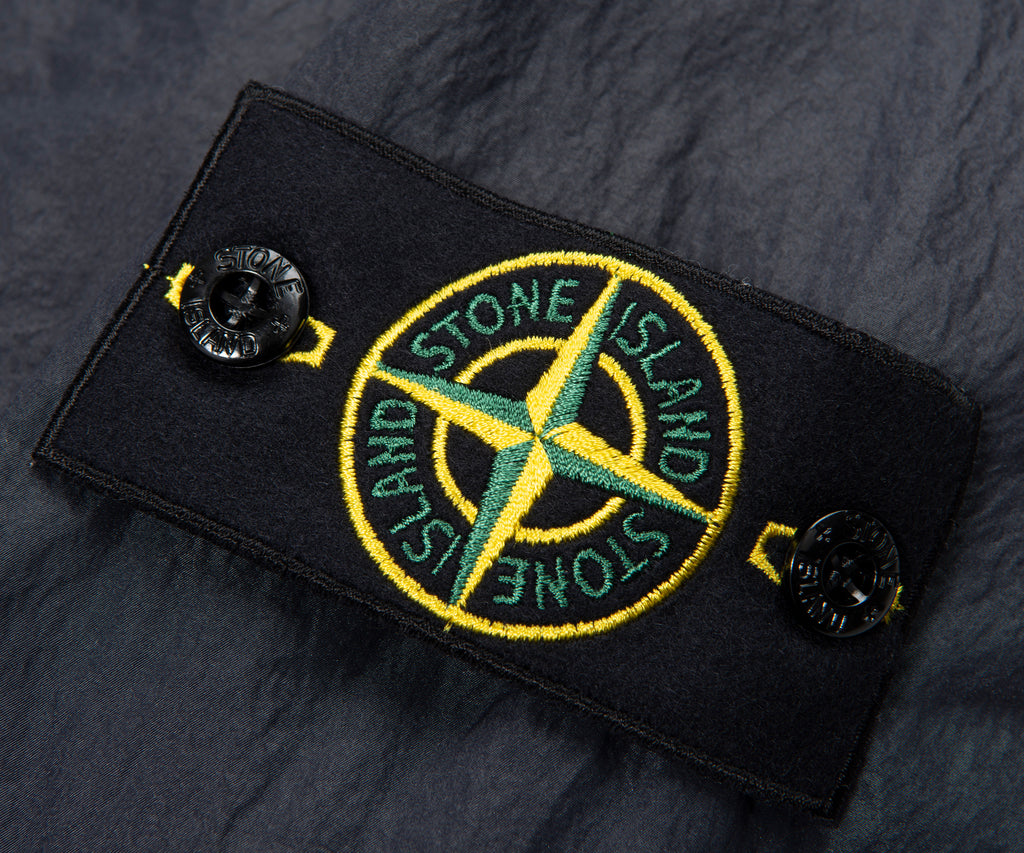Stone Island logo patch on a dark fabric background