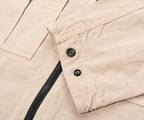 Close-up of beige fabric with a zipper and buttons