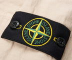 Close-up of a Stone Island patch on a beige background