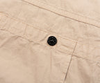 Close-up of beige fabric with a black button