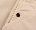Close-up of beige fabric with a button on a beige background