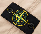 Close-up of Stone Island patch on a beige background
