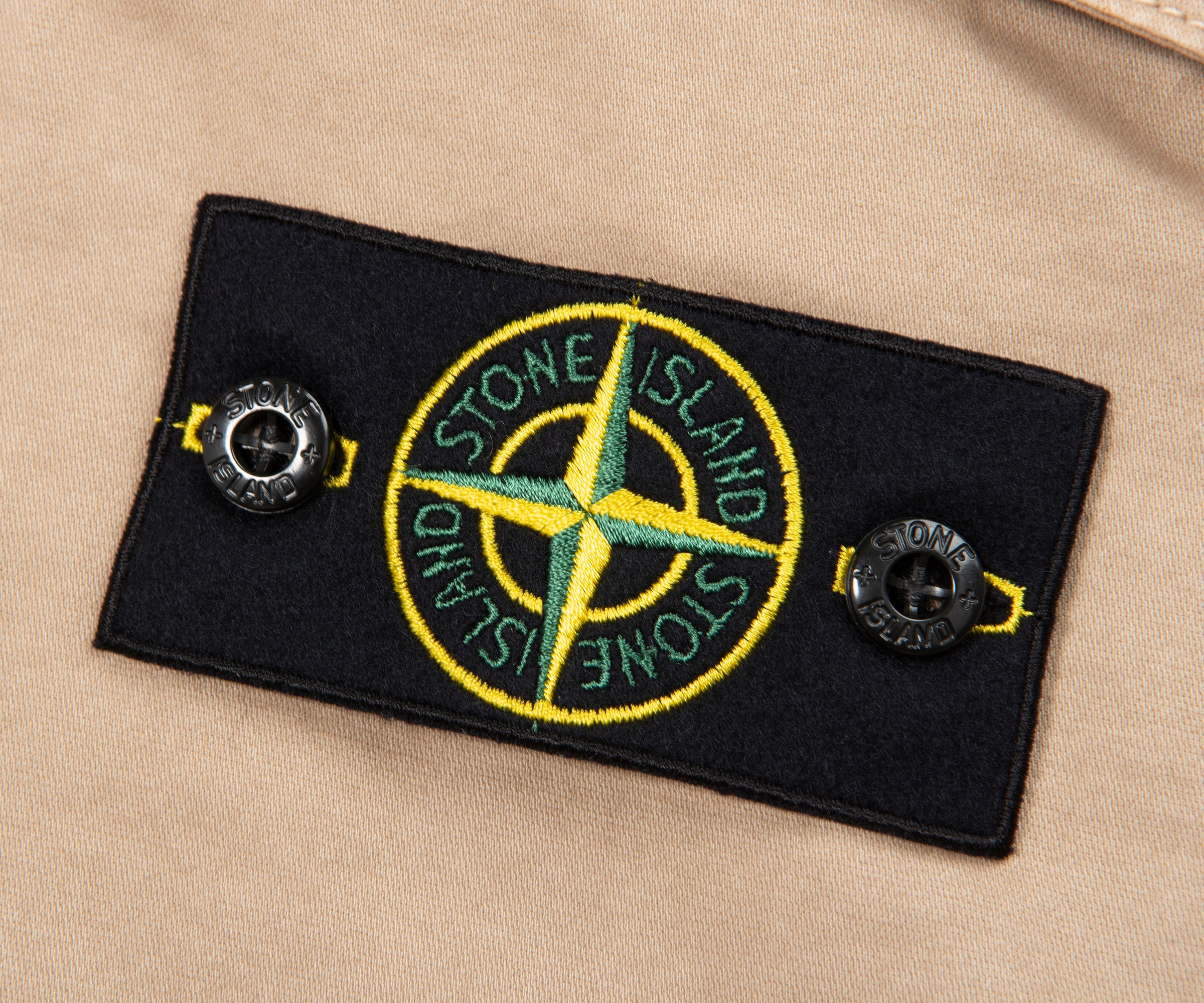 Stone Island patch on a beige background