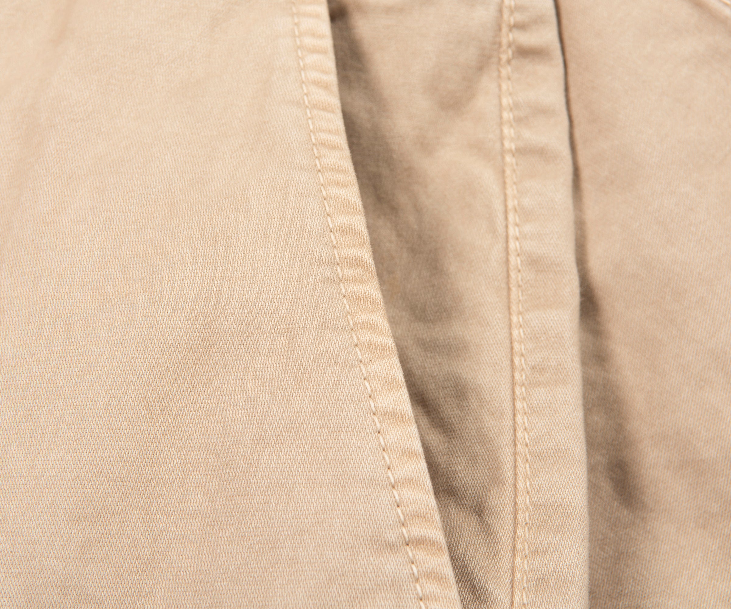 Close-up of beige fabric with a visible seam