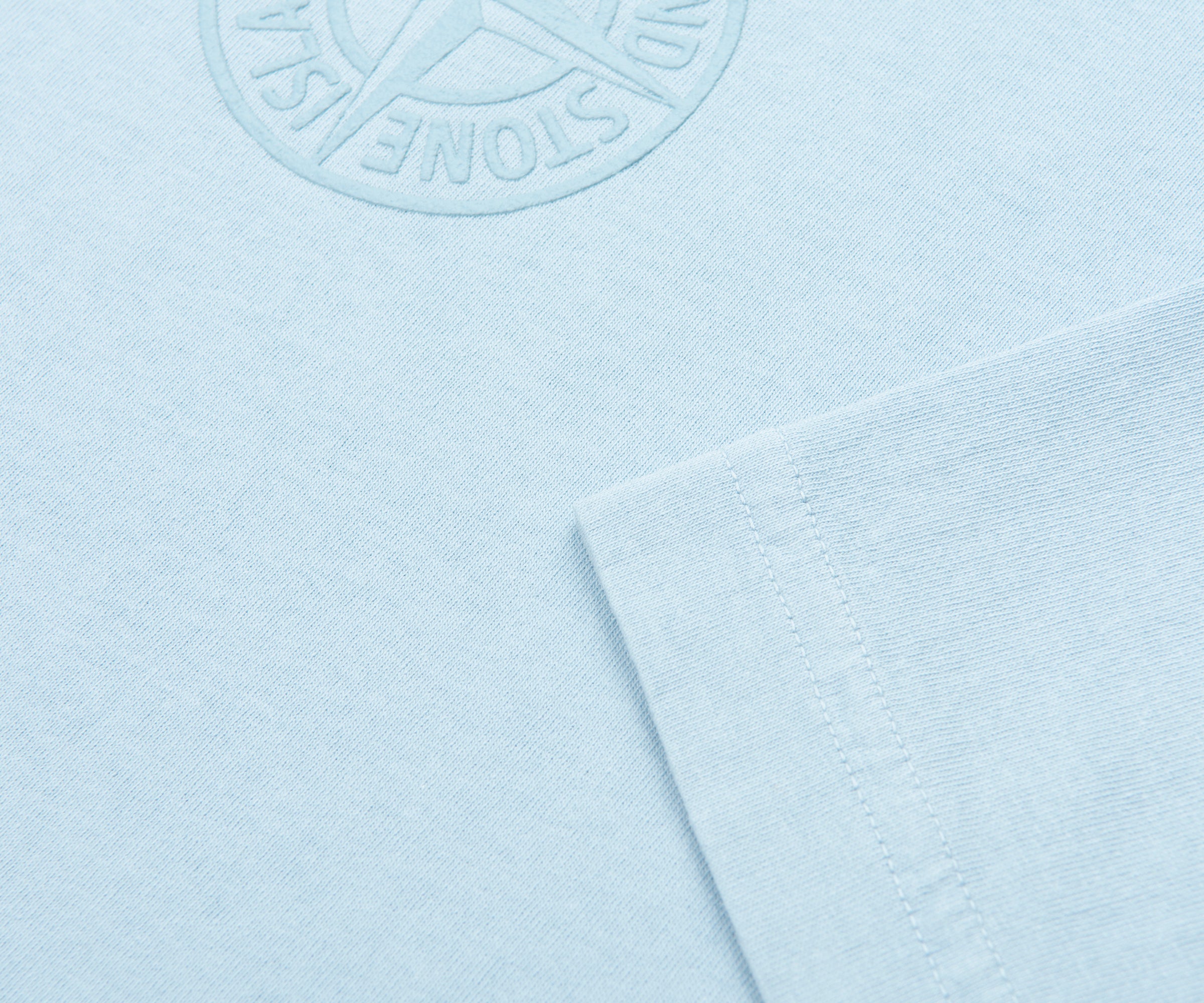 Light blue fabric with a brand logo on a light blue background