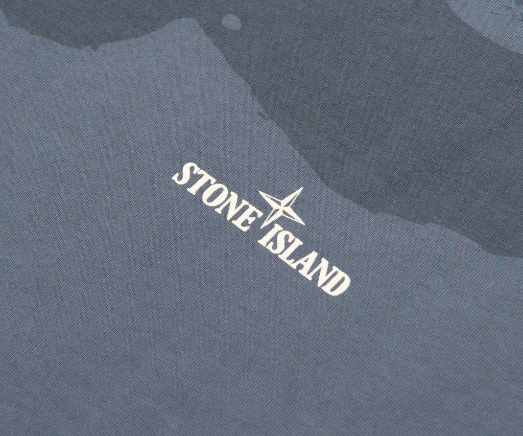 Close-up of Stone Island logo on a textured fabric background