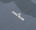 Close-up of Stone Island logo on a textured fabric background