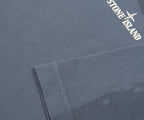 Close-up of a gray fabric with Stone Island logo on a gray background