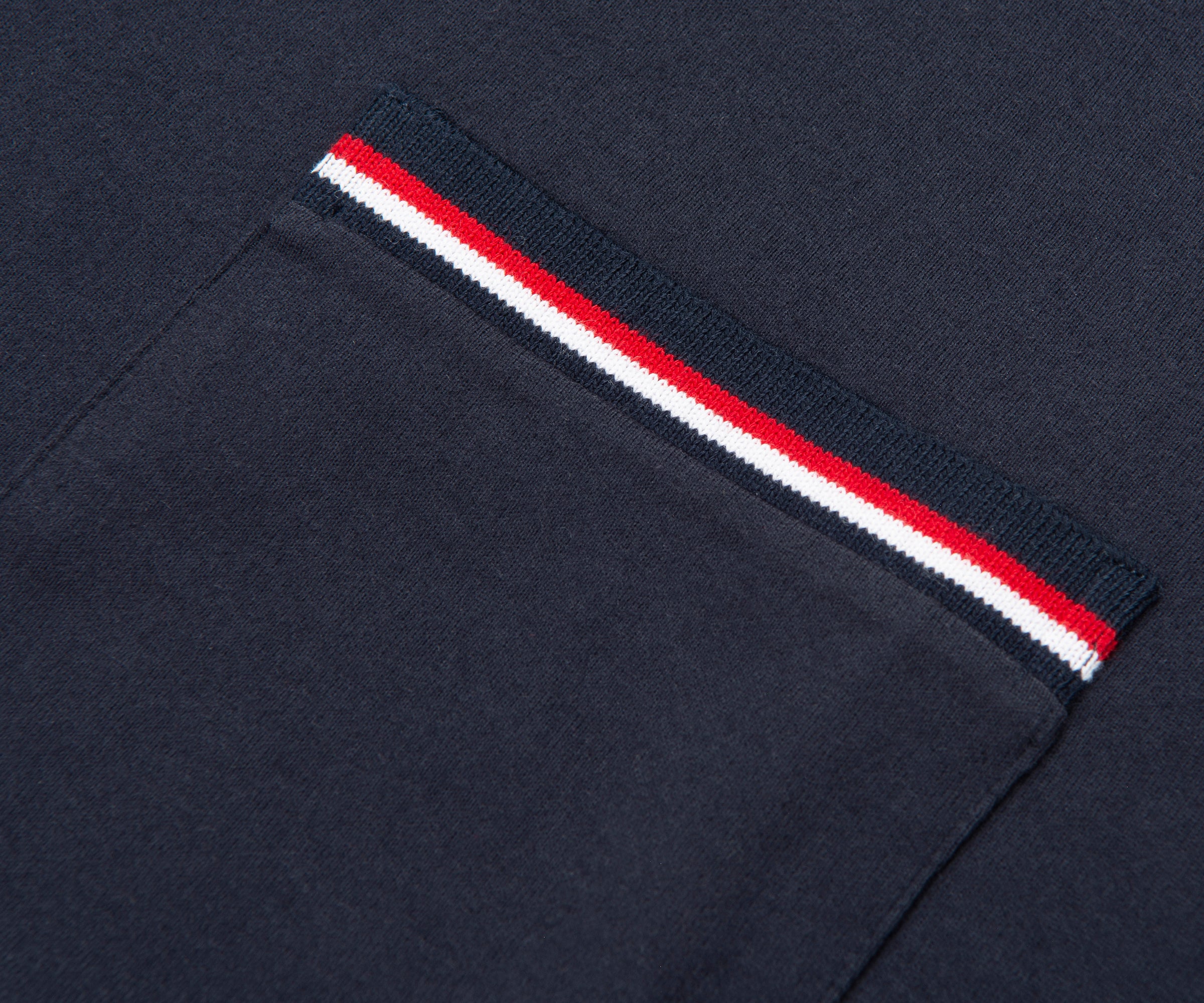 Navy blue sweater with a red and white striped trim on a dark background