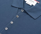 Close-up of a blue polo shirt with buttons and a brand tag.