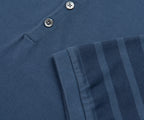 Close-up of a blue Adidas sweatshirt with three stripes on the sleeve.