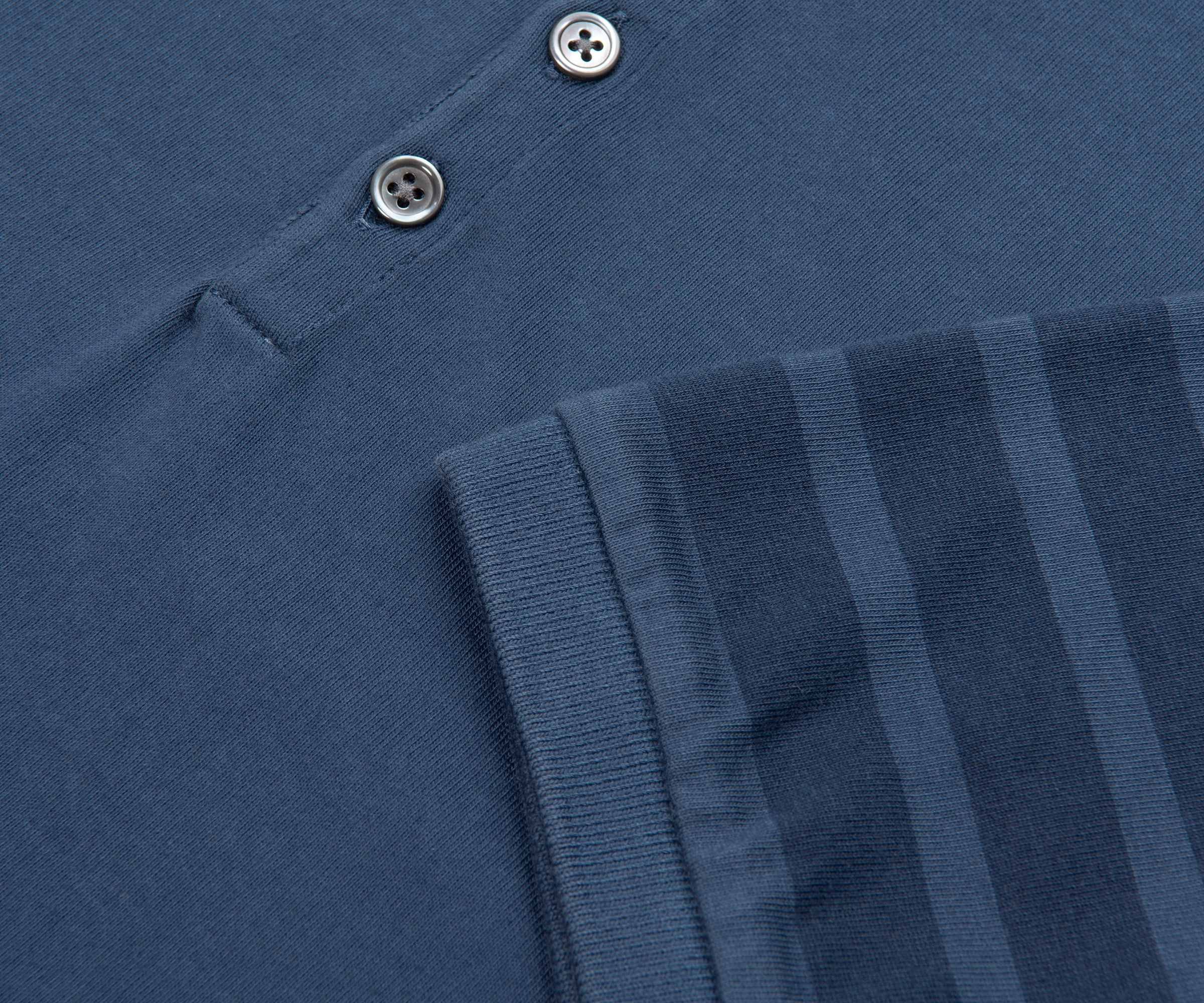 Close-up of a blue Adidas sweatshirt with three stripes on the sleeve.