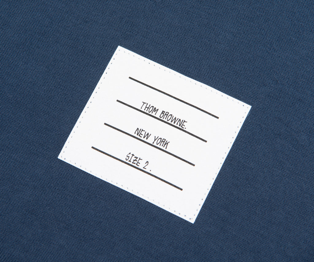 Thom Browne label on a blue fabric background
