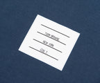 Thom Browne label on a blue fabric background