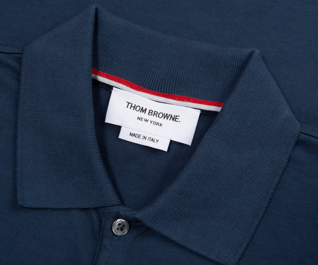Navy polo shirt collar with a Thom Browne label