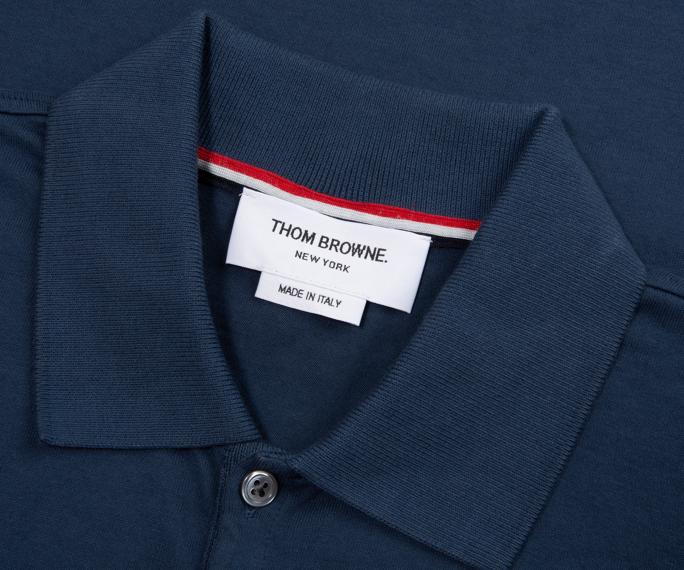 Navy polo shirt collar with a Thom Browne label