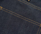 Close-up of dark blue denim fabric with visible stitching