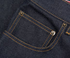 Close-up of a pocket on a dark blue denim fabric with stitching details.