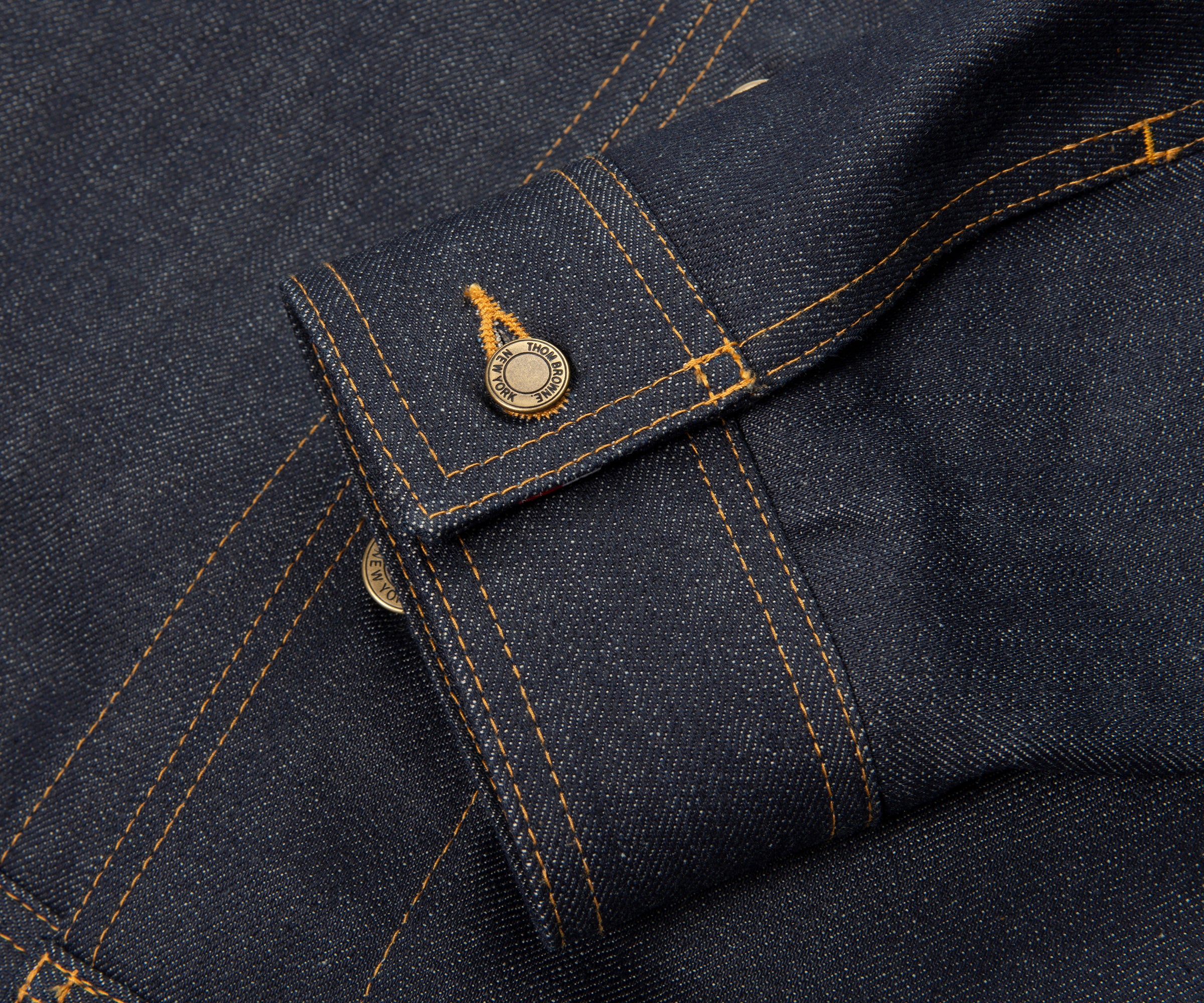 Close-up of a dark blue denim fabric with stitching details