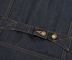 Close-up of a button on a dark blue denim fabric with stitching details.