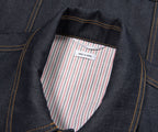 Close-up of a denim jacket with a striped pocket and 'Made in Japan' label.